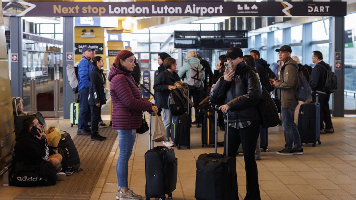 Pasajeros esperan con sus equipajes en el aeropuerto británico de Luton